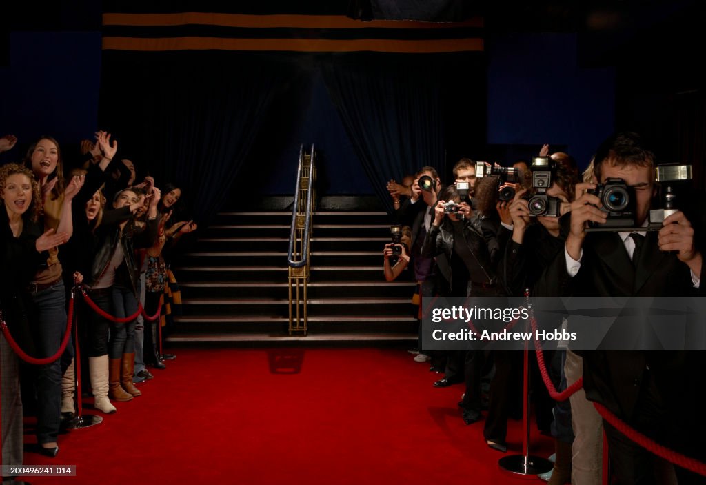 Paparazzi and excited fans greeting celebrity arrivals on red carpet