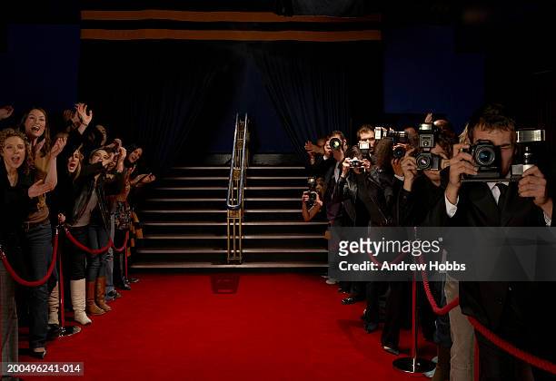 paparazzi and excited fans greeting celebrity arrivals on red carpet - red carpet event stock-fotos und bilder
