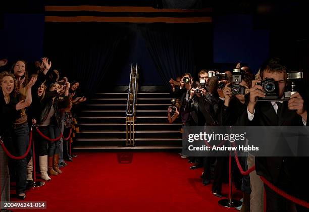 paparazzi and excited fans greeting celebrity arrivals on red carpet - roped off 個照片及圖片檔