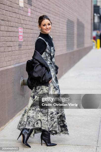 Olivia Palermo wears black white dress with graphic print, bomber jacket, black turtleneck, boots outside Jason Wu on February 11, 2024 in New York...