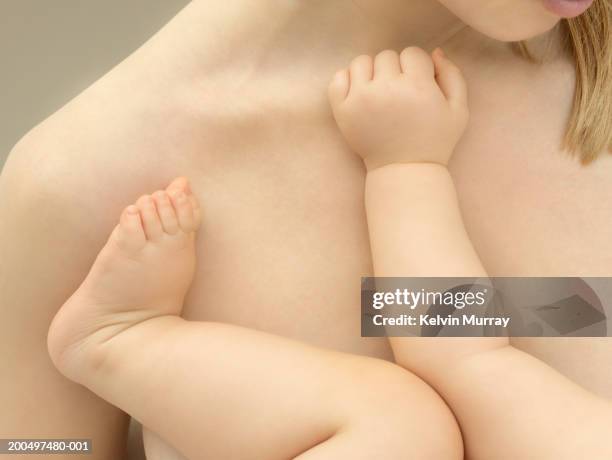 mother holding baby boy (9-12 months), close-up, mid section - baby skin fotografías e imágenes de stock