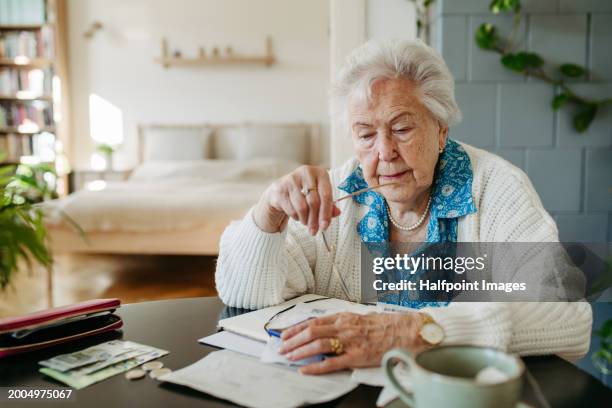 senior woman has financial problems. counting money, monthly pension, don’t have enough money for paying bills. - pensão documento bancário imagens e fotografias de stock