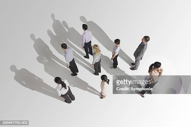 businesswoman looking in different direction than colleagues - elevated view of person on white background stock pictures, royalty-free photos & images