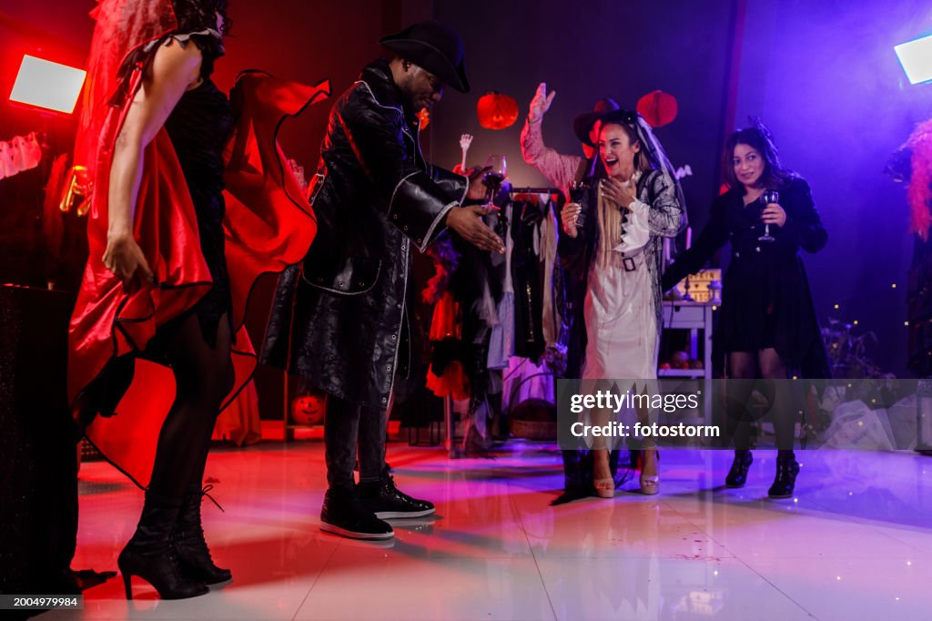 Cheerful group of friends dancing during a fun Halloween party