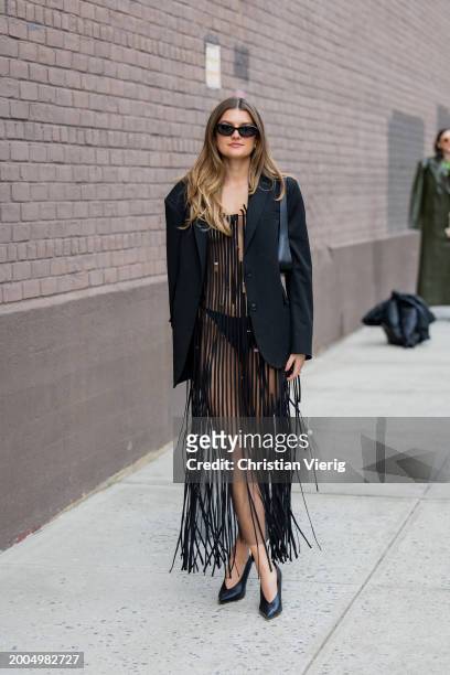 Sara Walker wears black transparent fringed dress, blazer outside Jason Wu on February 11, 2024 in New York City.