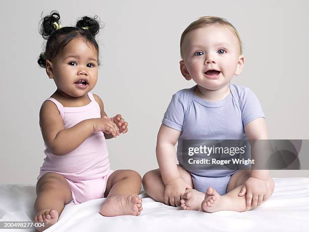 baby girl and baby boy (6-9 months) sitting, portrait - baby girls stock-fotos und bilder