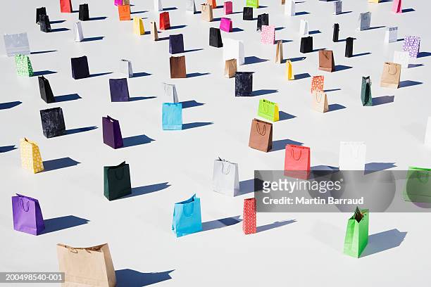 colourful shopping bags placed on white platform, elevated view - shopper bag fotografías e imágenes de stock