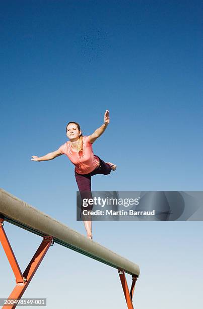 female gymnast balancing on balance beam, low angle view - poutre photos et images de collection