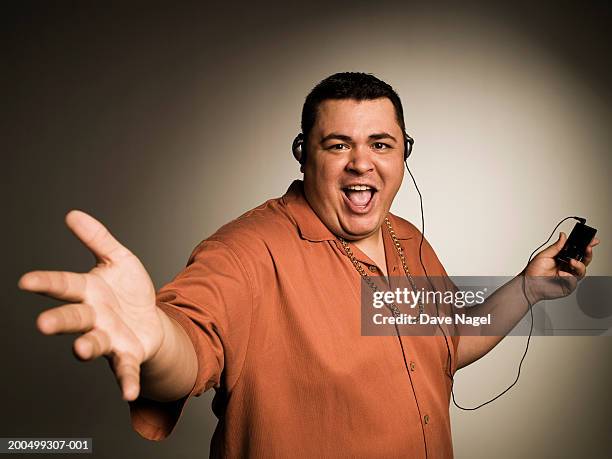 young man listening to mp3 player, portrait - chubby men stock pictures, royalty-free photos & images