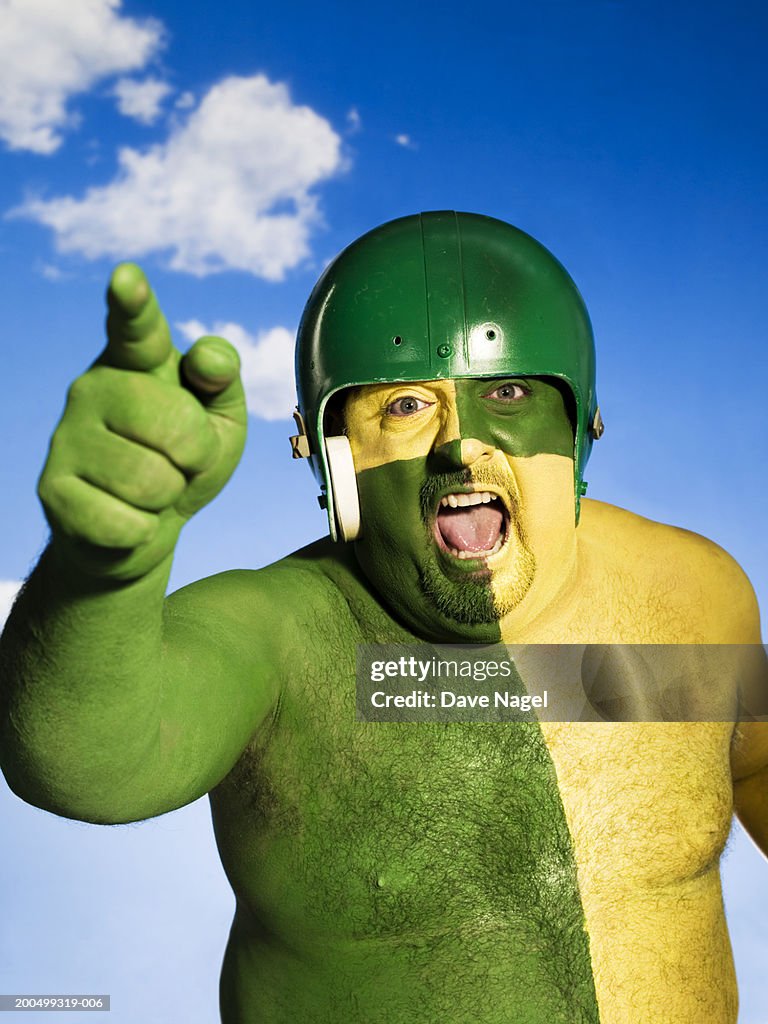 Man with face and body painted green and yellow, portrait