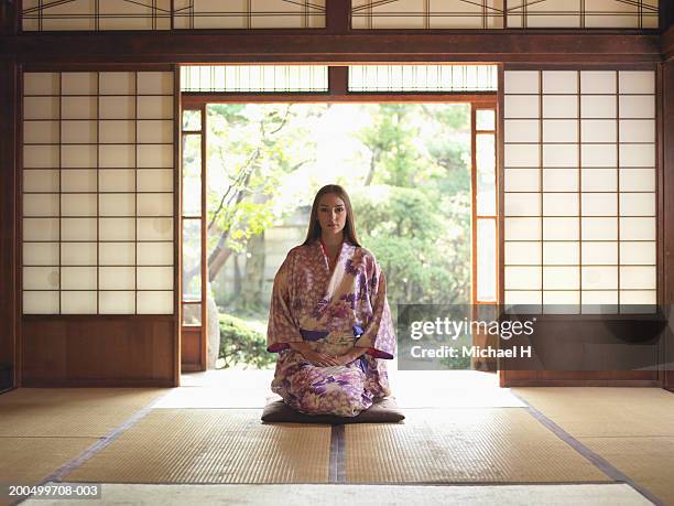 japan, tokyo, young woman in kimono kneeling on tatami mat, portrait - shoji fotografías e imágenes de stock
