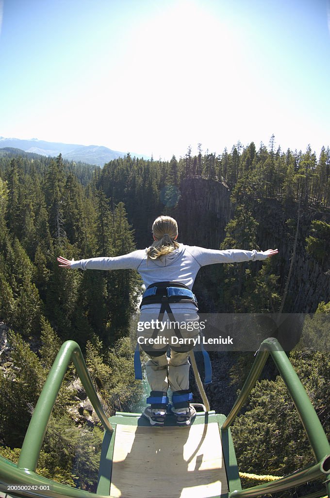 Young woman bungee jumping, rear view, (wide angle)