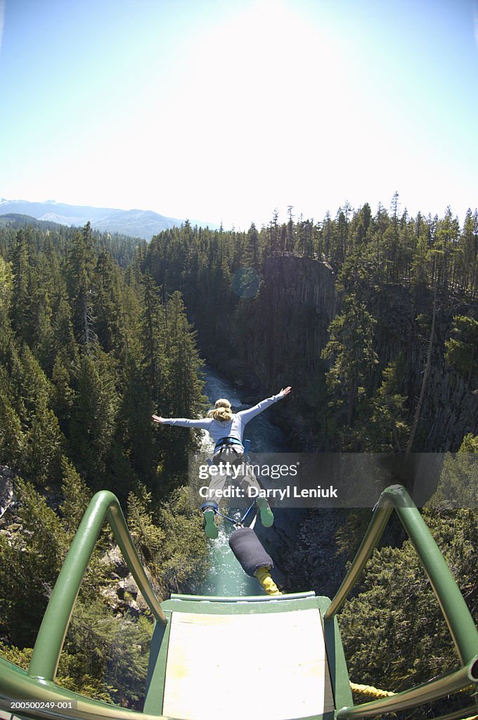 Young woman bungee jumping, elevated view, (wide angle)