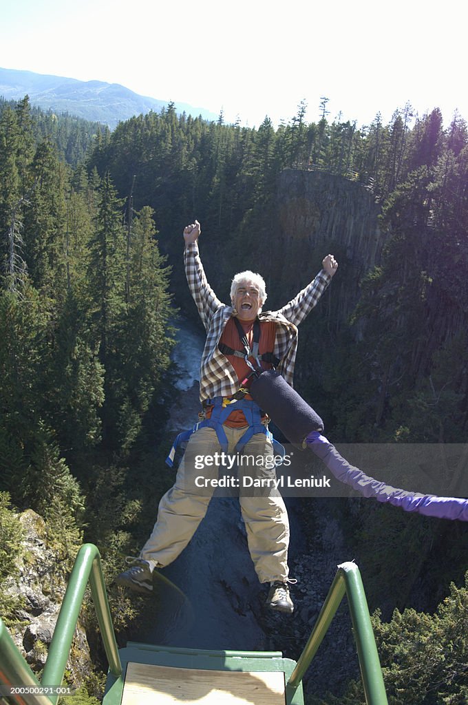 Mature man bungee jumping, elevated view, (wide angle)