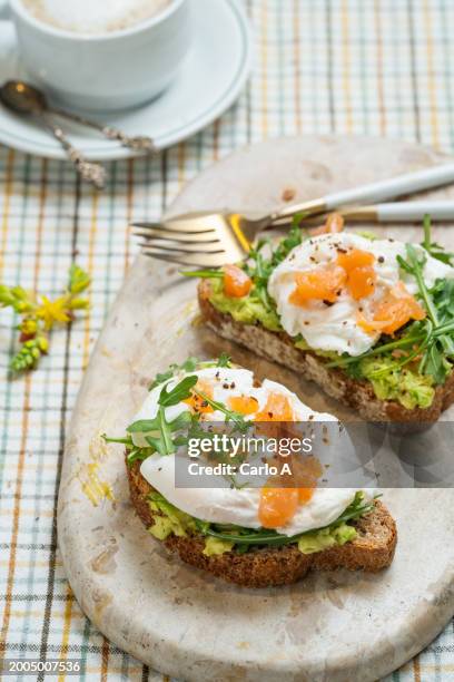 poached eggs and salmon tartare on avocado toast - zalm gerecht stockfoto's en -beelden