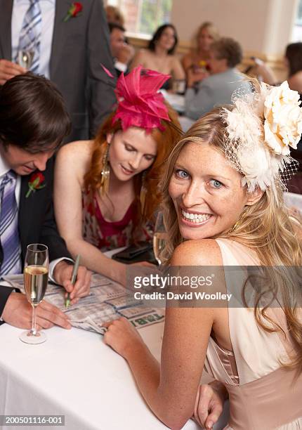 woman sitting with friends at race day, smiling, portrait - fascinator 個照片及圖片檔