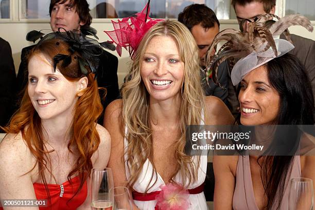 three women at the races, smiling - fascinator 個照片及圖片檔