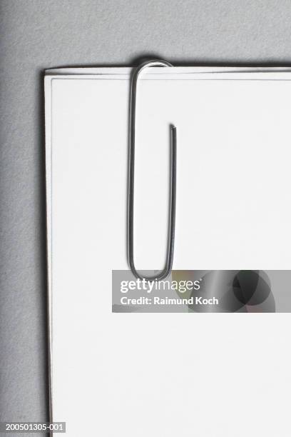 paper clip holding three sheets of white paper - trombone photos et images de collection