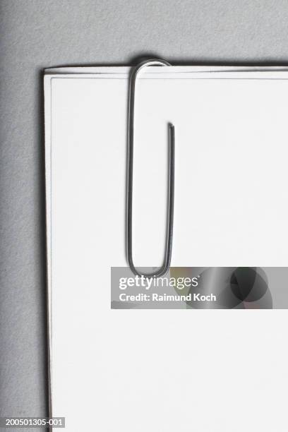 paper clip holding three sheets of white paper - paperclip imagens e fotografias de stock