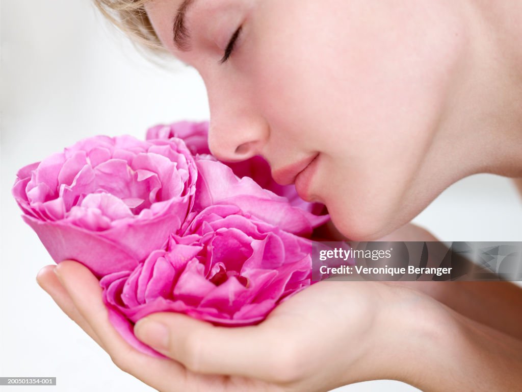 Teenage girl (16-18) smelling roses, close-up, side view