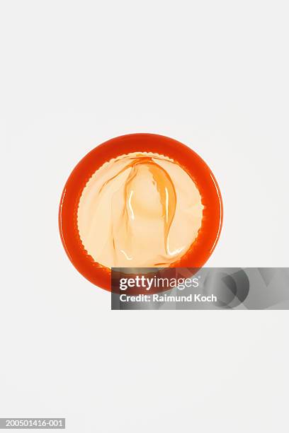 unused orange condom on white background - condom stock pictures, royalty-free photos & images