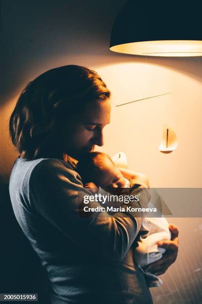 mother cradling baby at the night. - moder maria bildbanksfoton och bilder