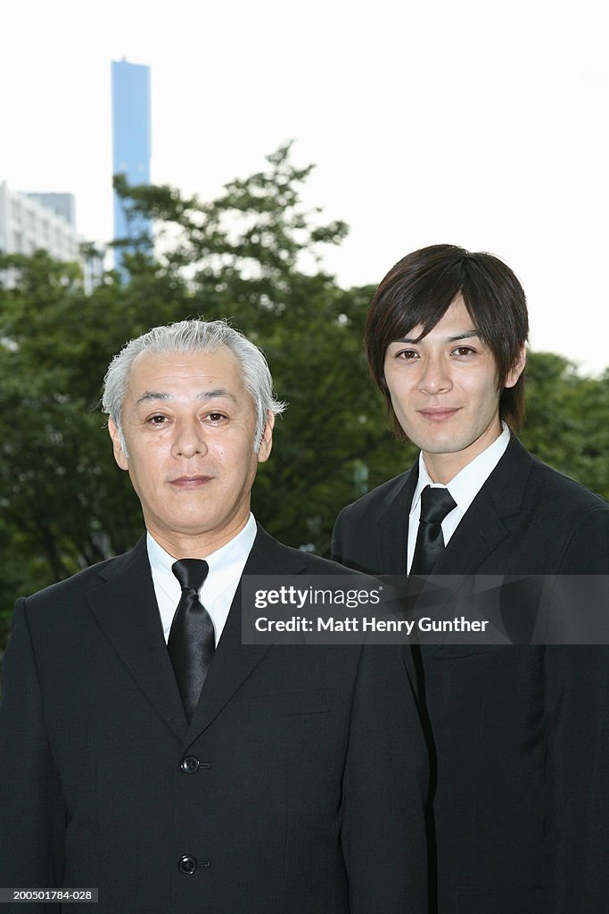 Two businessmen standing side by side outdoors, portrait