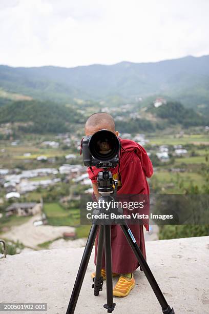 bhutan, bumthang, monk lookihn through camera - vista posterior stock-fotos und bilder