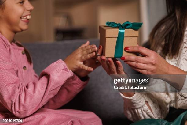 excited young girl surprising her mother with a gift box - open gift stock pictures, royalty-free photos & images