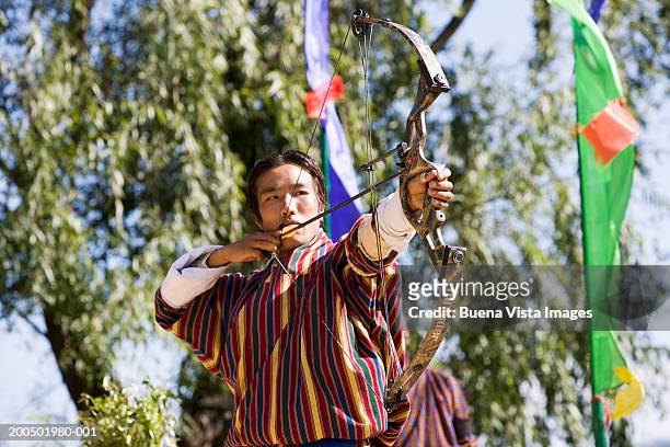 bhutan, paro, man in archery competition - bhutan archery stock pictures, royalty-free photos & images