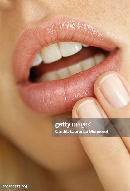 young woman touching lips, close-up - finger on lips stock-fotos und bilder