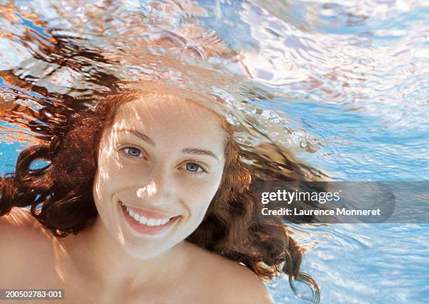 young woman underwater, smiling, portrait - portrait schwimmbad stock-fotos und bilder