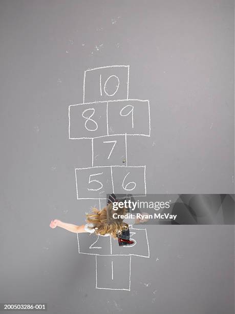 girl (8-10) playing hopscotch, overhead view - hopscotch stock-fotos und bilder