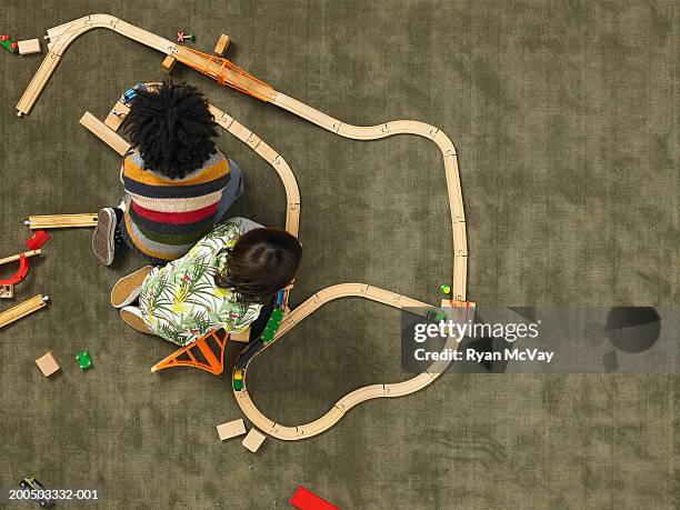 two boys (5-7) playing with train set, overhead view - toy train set stock pictures, royalty-free photos & images