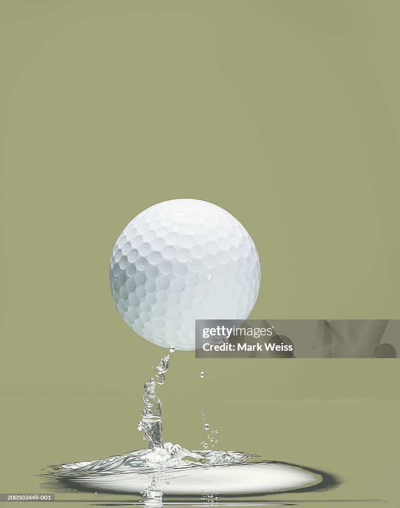Golf ball above puddle of water, close-up