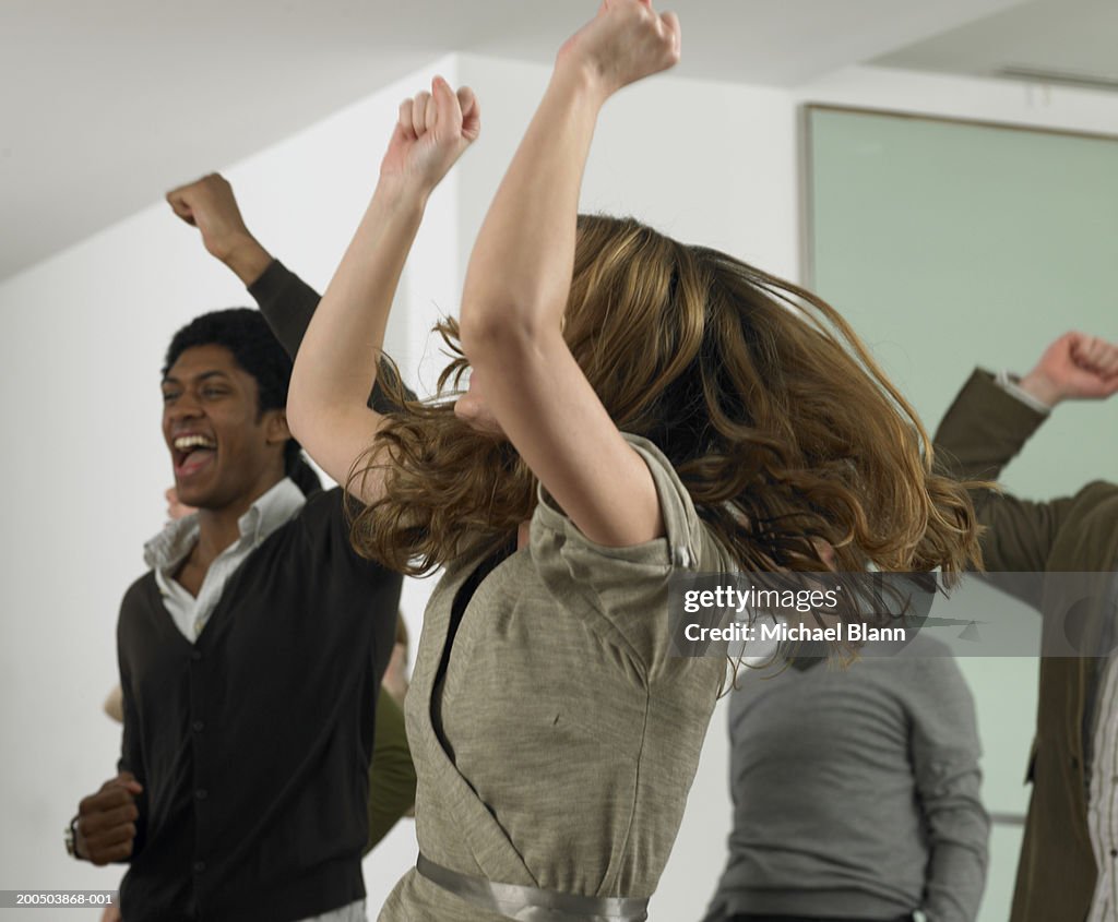 Business people punching air in office, cheering