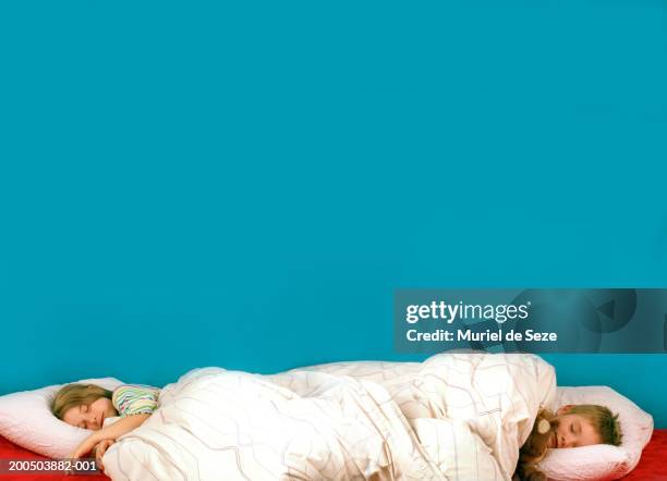 brother and sister (6-8) sleeping in opposite ends of bed - bed side view stock pictures, royalty-free photos & images