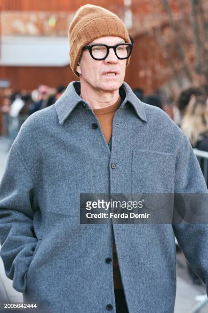 Guest wears grey double-face wool overshirt , black frame glasses with beanies knitted hat outside Zegna show during the Milan Fashion Week -...