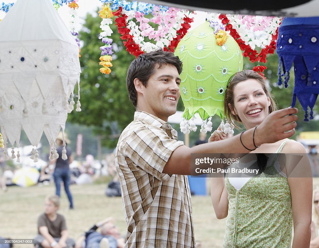 Young couple at festival, looking at lanterns, smiling