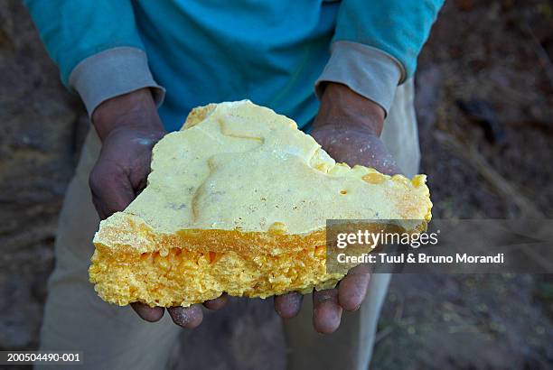 man holding sulphur, close-up - schwefel stock-fotos und bilder