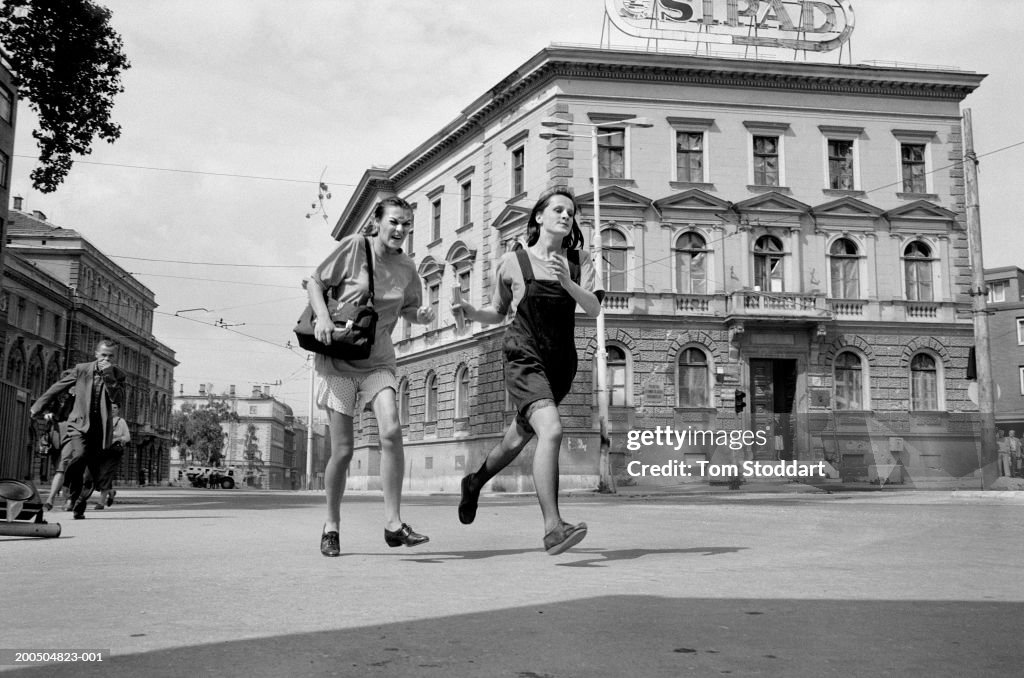 Bosnia, Sarajevo, Two teenage girls (14-16) running across Sniper Alley