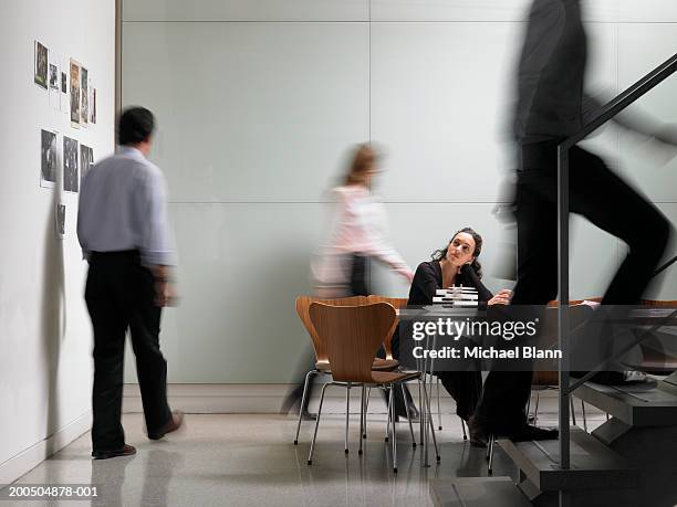 colleagues walking in board room, woman sitting at conference table - blurred motion foto e immagini stock