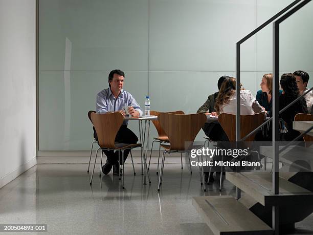 female colleagues having meeting in board room, man sitting alone - exclusion bildbanksfoton och bilder
