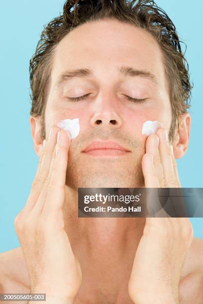 mature man applying face cream, eyes closed, close-up - cheveux court homme photos et images de collection