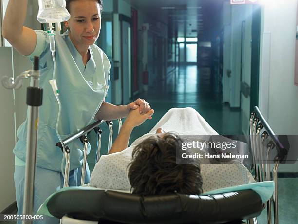 female nurse by patient on bed walk in hospital - ziekenhuisbed stockfoto's en -beelden