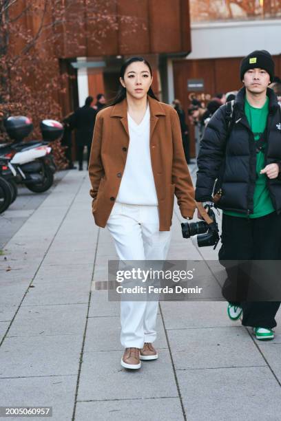 Guest wears Zegna Alpe Chore button-up shirt jacket, Zegna triple stitch suede sneakers, v-neck white sweater with white trousers outside Zegna show...