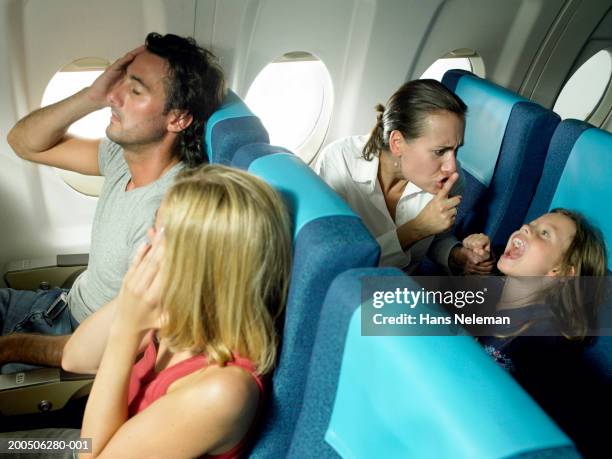 girl (5-7) yelling behind young couple in airplane - child shouting stock pictures, royalty-free photos & images