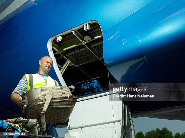 mature male luggage official carrying suitcase by plane - luggage hold stock pictures, royalty-free photos & images