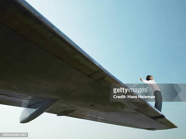 young man standing on wing of airplane - plane wing stock pictures, royalty-free photos & images