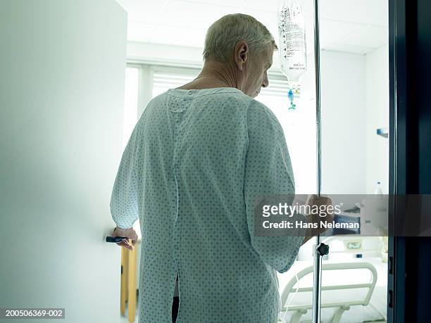 senior male patient walking with drip, rear view - hemodialisis fotografías e imágenes de stock